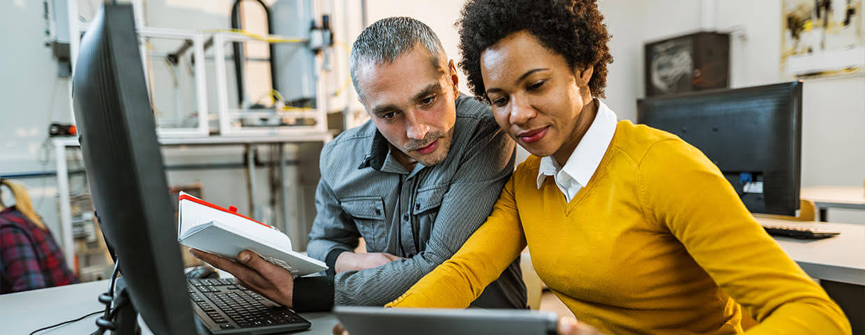 Two people reviewing computer screen